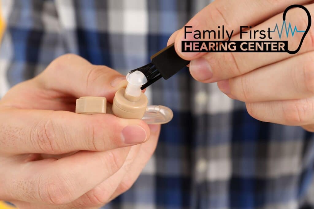 hands cleaning a hearing aid