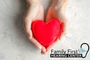 hands holding a bright red heart