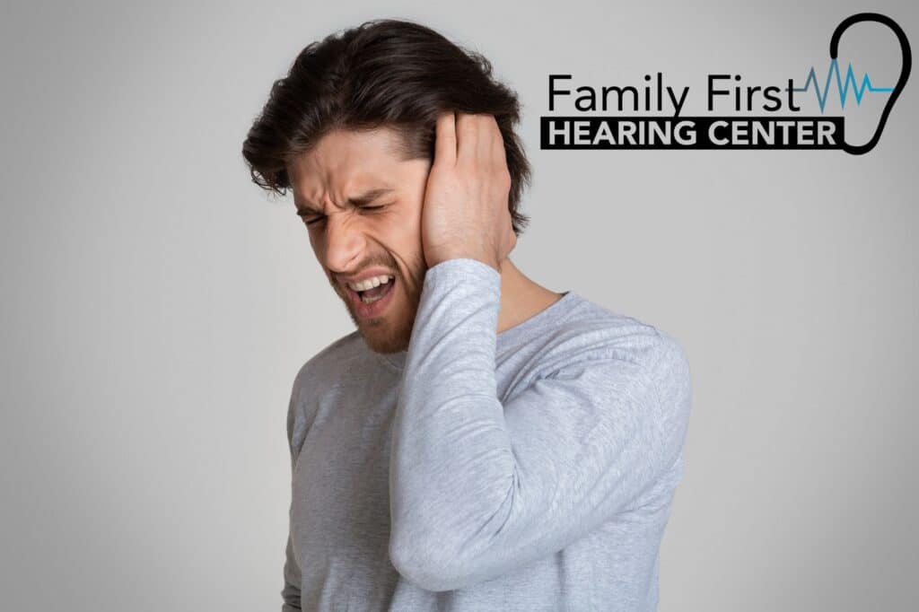man holding his ear in pain