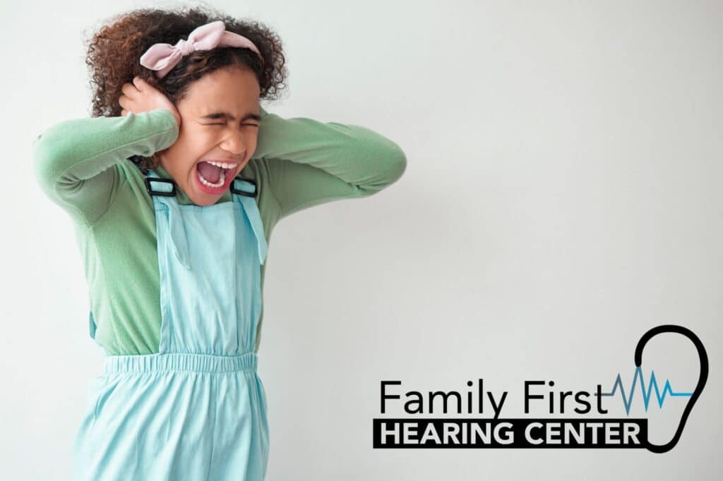 young girl holding her ears in pain