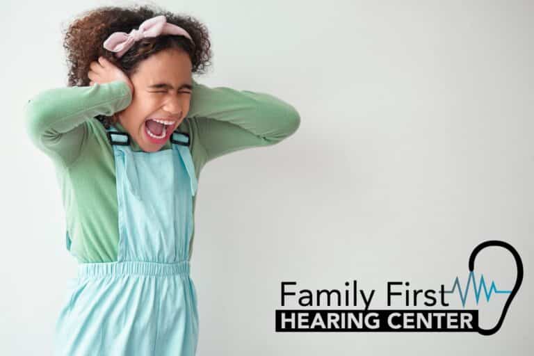 young girl holding her ears in pain