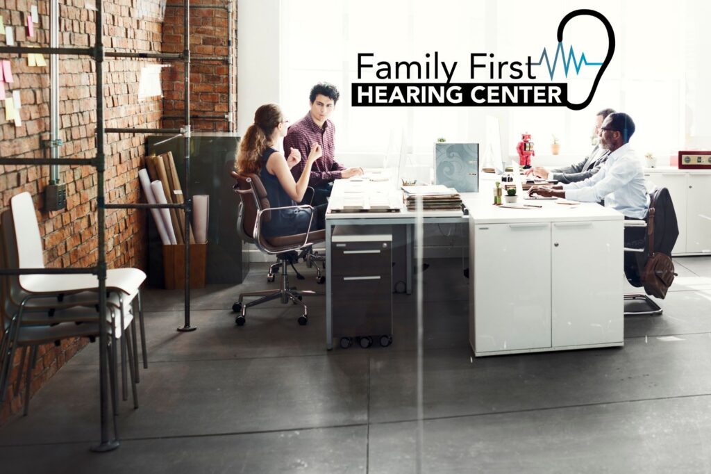 four people in a workplace talking
